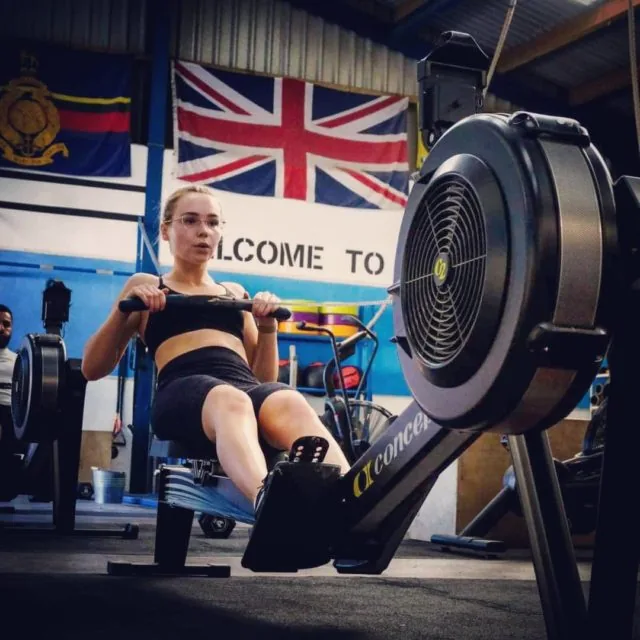 A member working hard on a rowing machine during a conditioning session