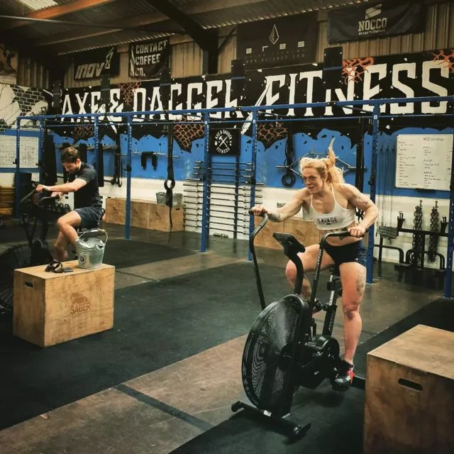 Members training on the box and the air bike under the Axe & Dagger Fitness wall at the gym in Bulkington