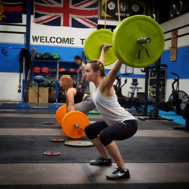 A member catching a snatch in a deep overhead squat under the Union Jack